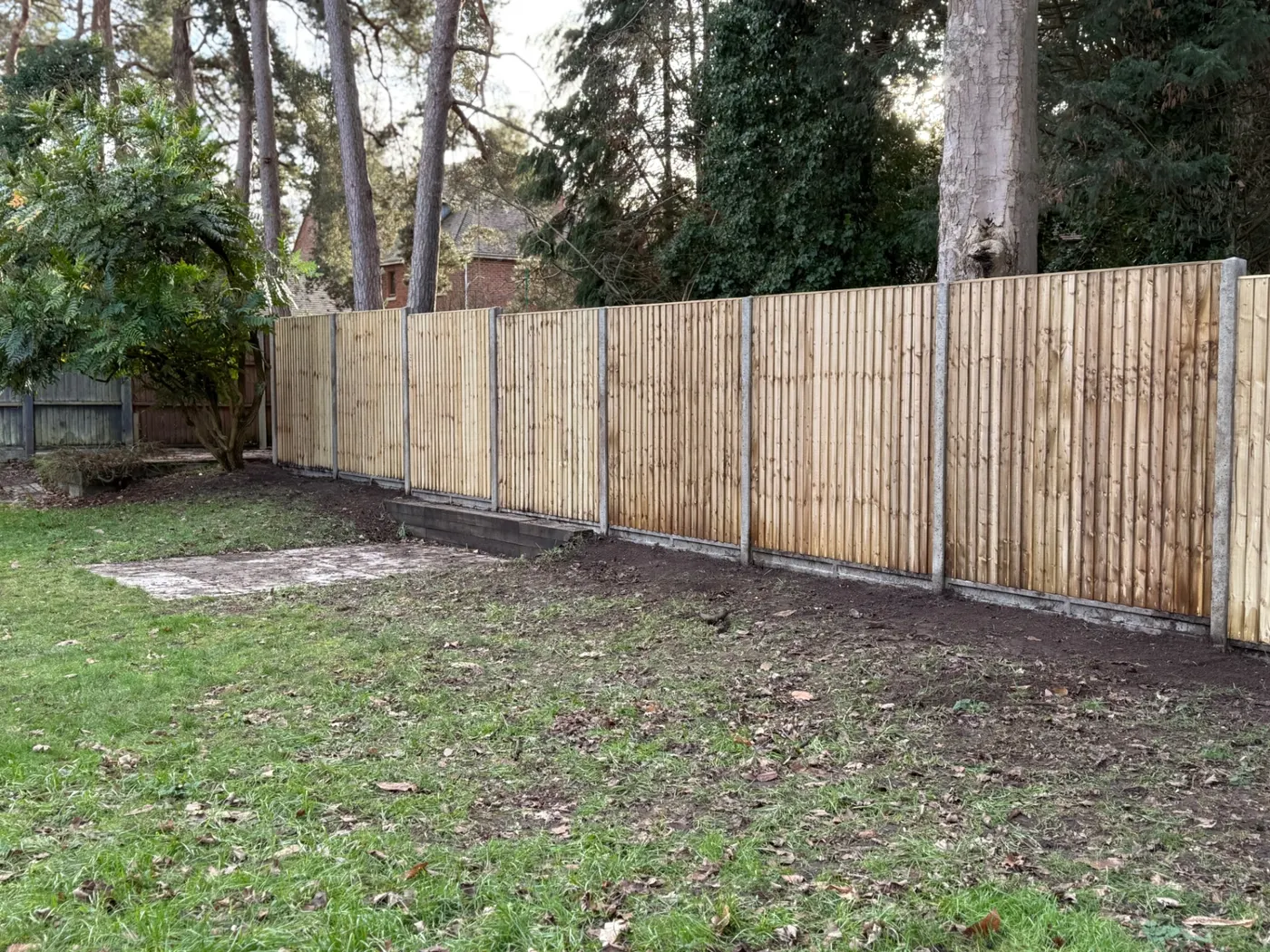 Long closeboard boundary fence installed in a large Farnham garden
