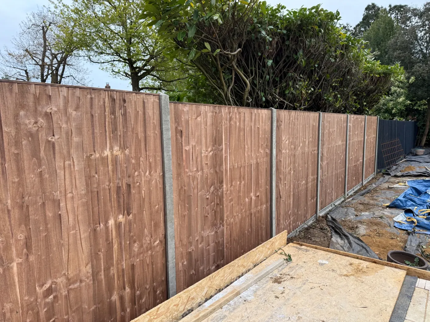 Brown stained feather edge fencing with concrete posts in Surrey
