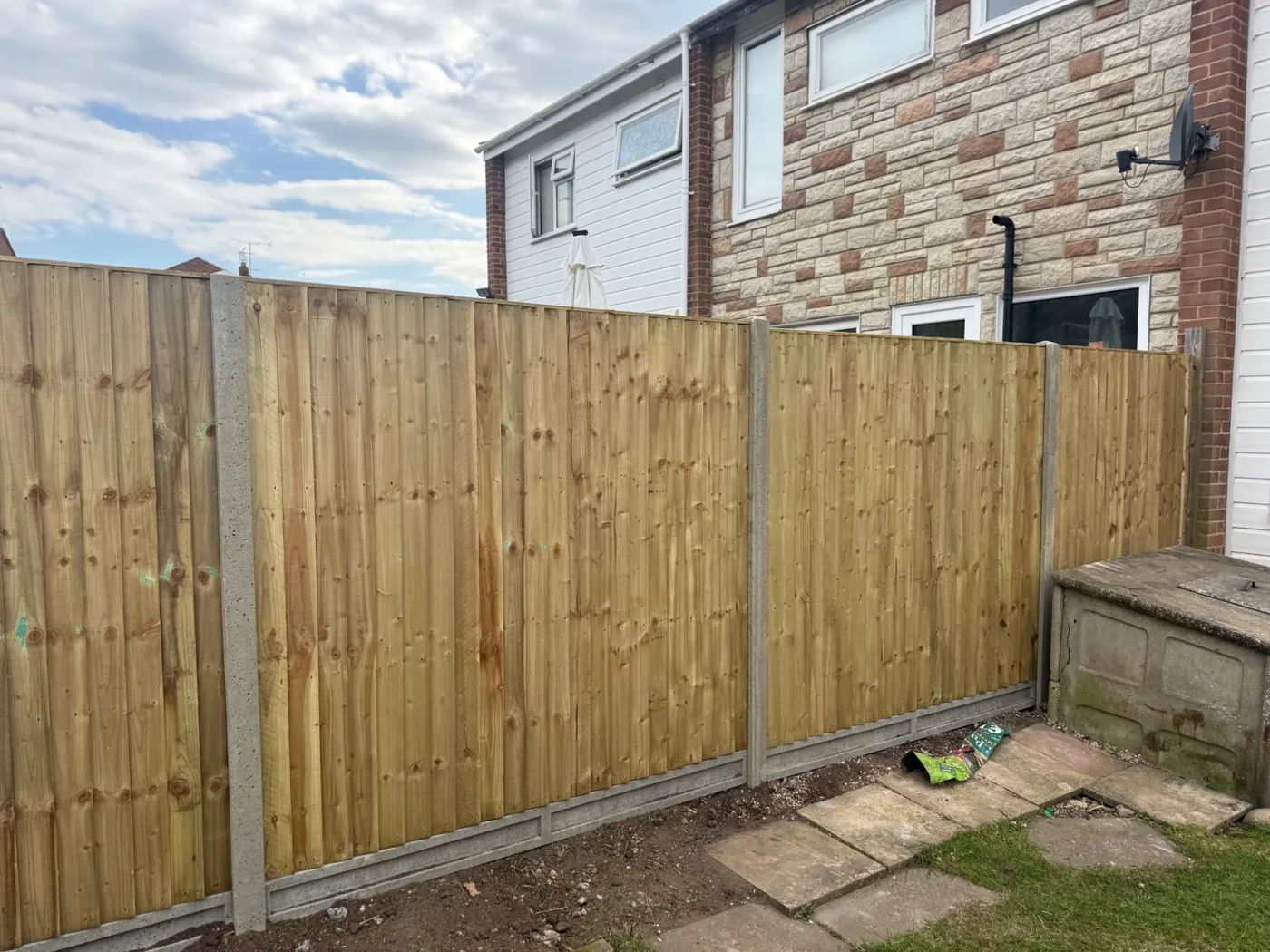 New feather edge fence panels with concrete posts behind a Farnham home