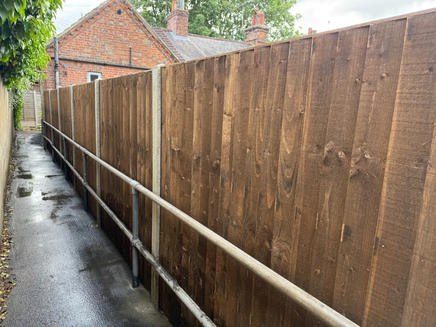 Tall closeboard boundary fence along an access lane in Farnham