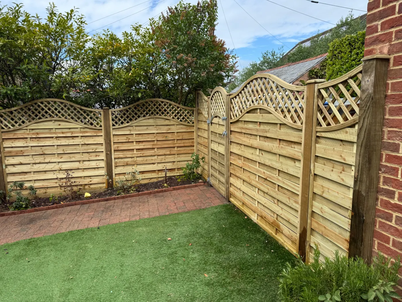 Decorative wave trellis top fence panels and matching gate in Farnham