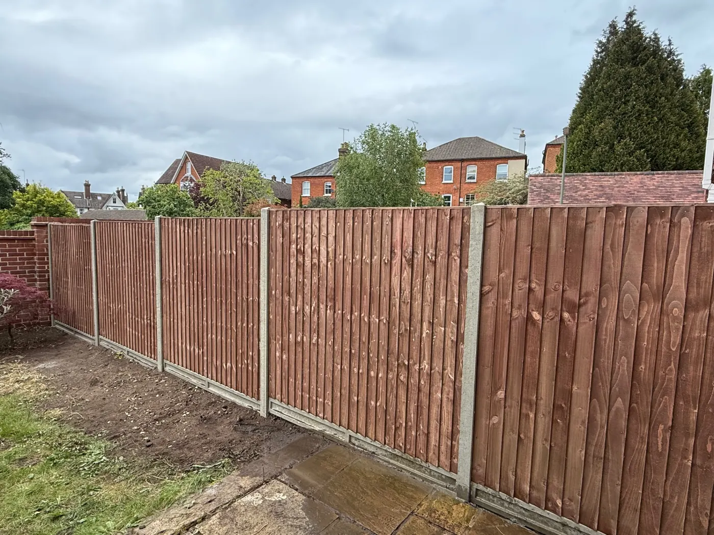 Feather edge fencing with concrete posts and gravel boards in Farnham