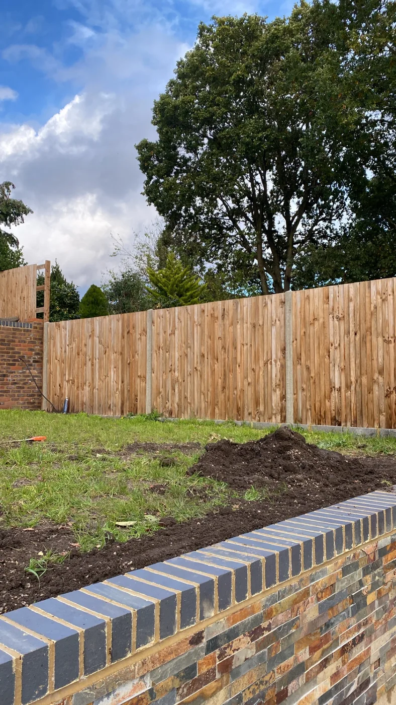 New closeboard fence panels above a brick garden wall in Farnham