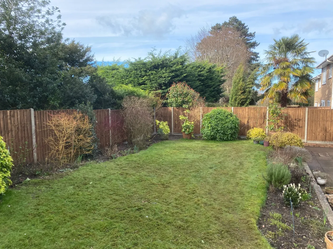 Full garden boundary fence installation around a lawn in Surrey