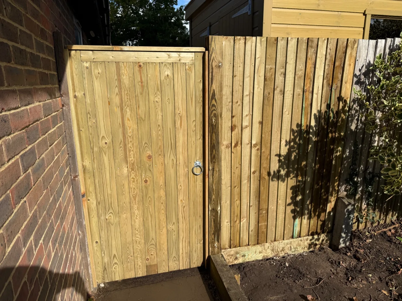 Tongue and groove garden gate beside new closeboard fencing