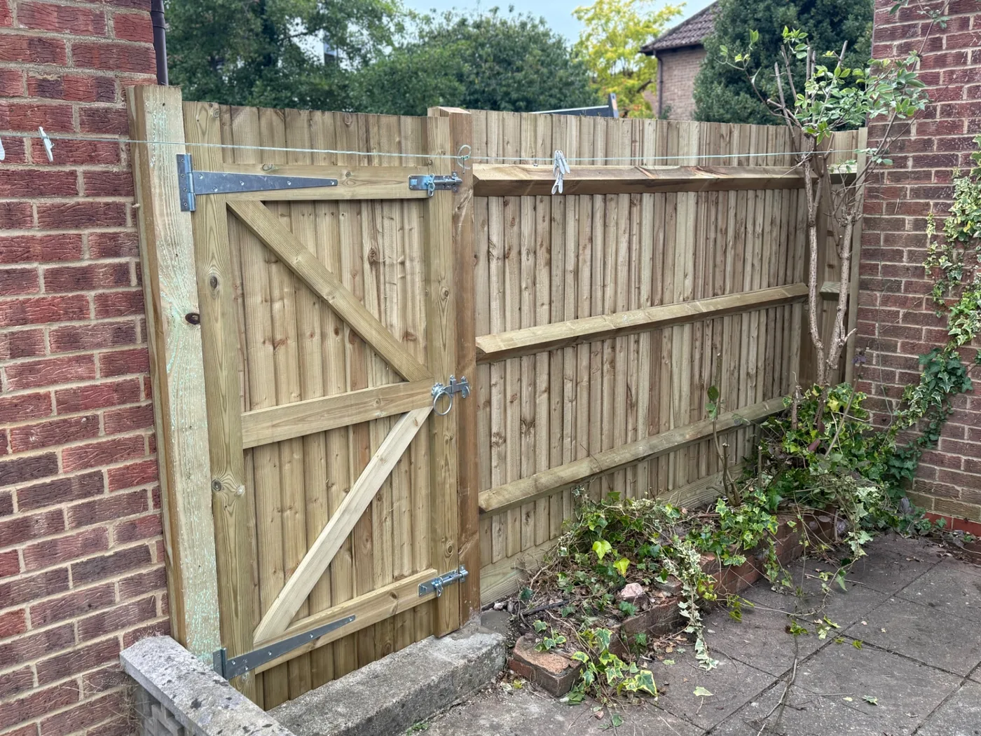 Braced closeboard side gate hung between brick walls in Farnham