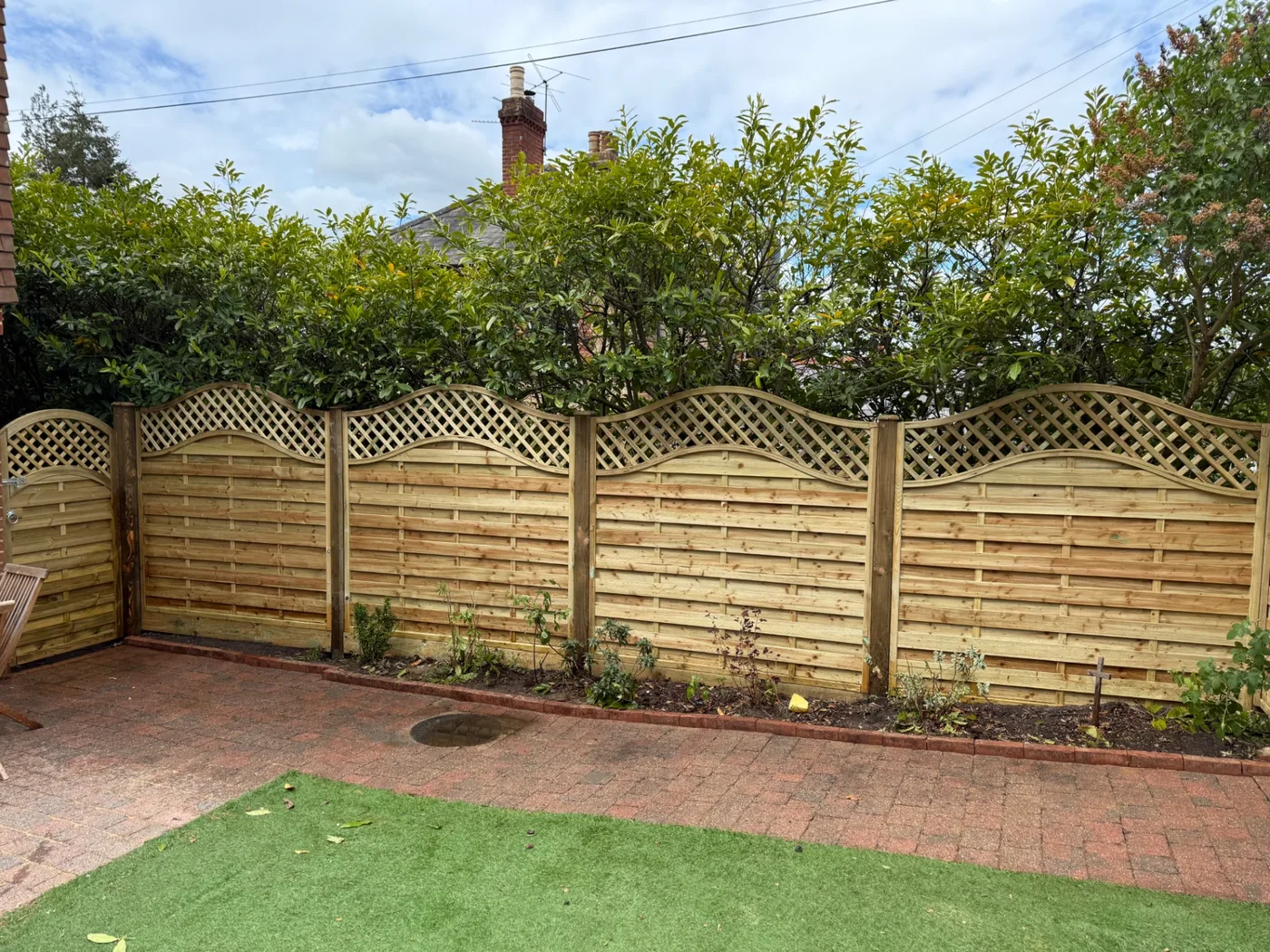 Decorative wave trellis topped fence panels in a Farnham garden
