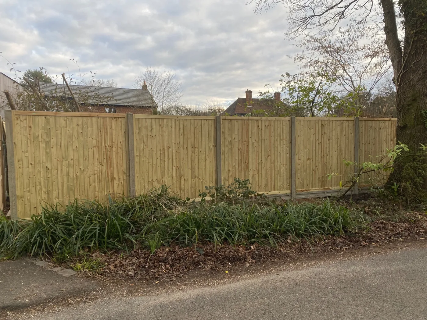 Long run of new fence panels along a roadside boundary near Farnham
